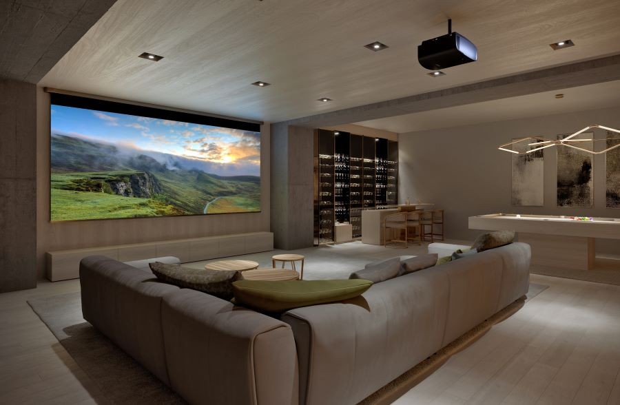 A home theater with a sectional, large screen, projector, pool table, and wine tasting area.