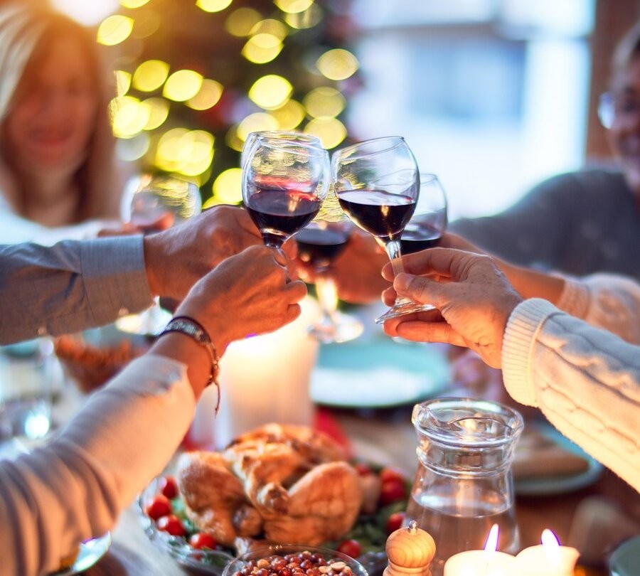 A holiday gathering around the table to a drinking toast.