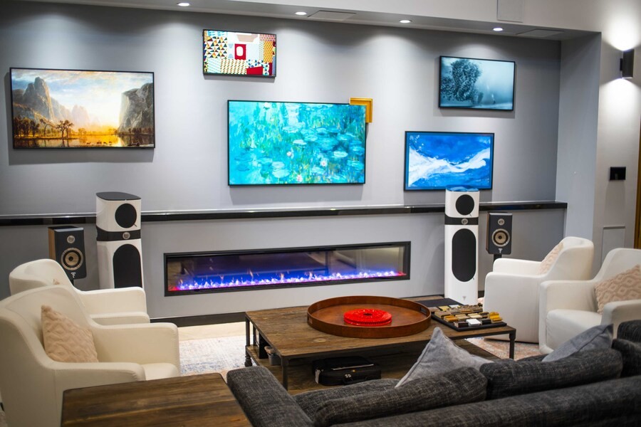 A luxury living room with high-end loudspeakers and colorful artwork on the wall.
