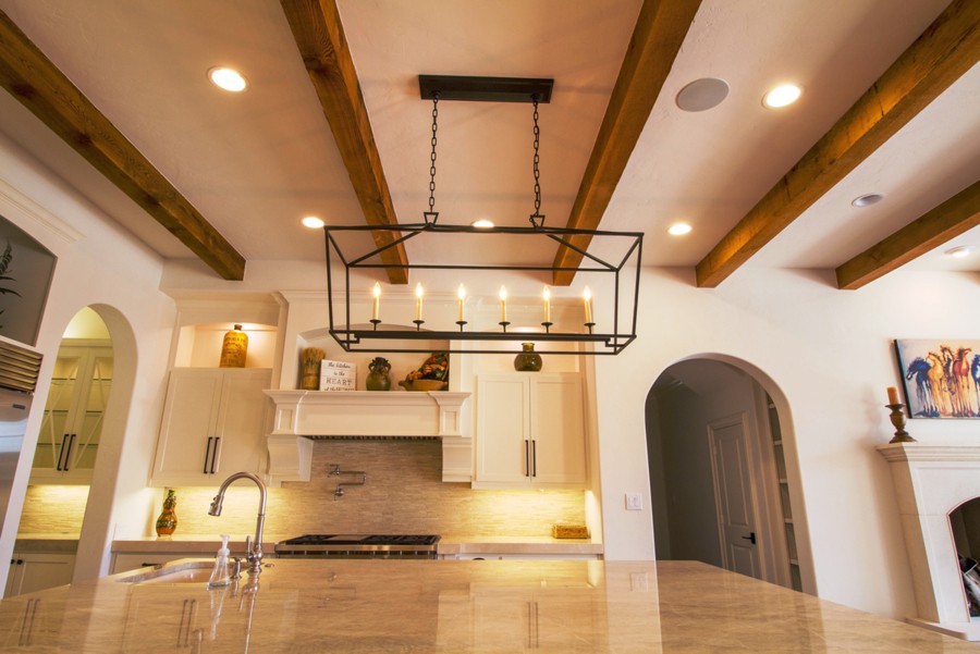 A beautifully lit kitchen with recessed, pendant, and under-cabinet lighting. 